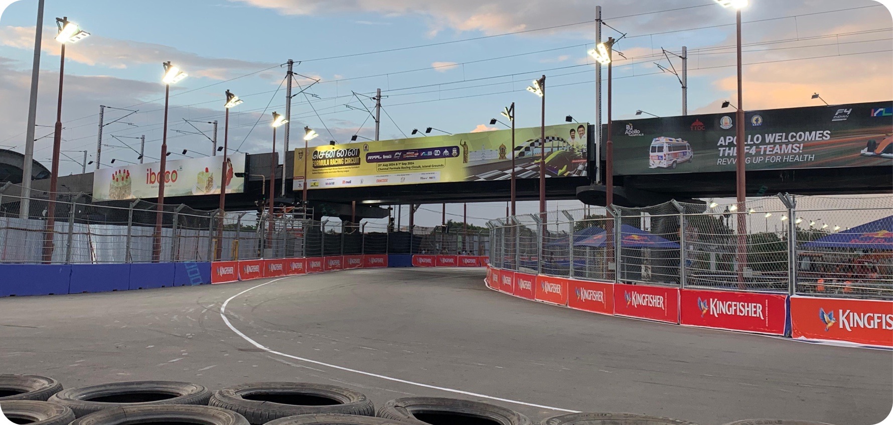 Street circuit barriers and billboards in Chennai at dusk.